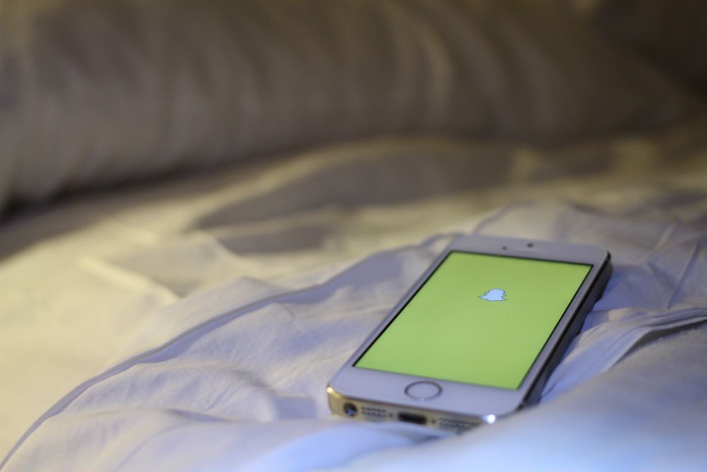 Snapchat open on iPhone placed on bed